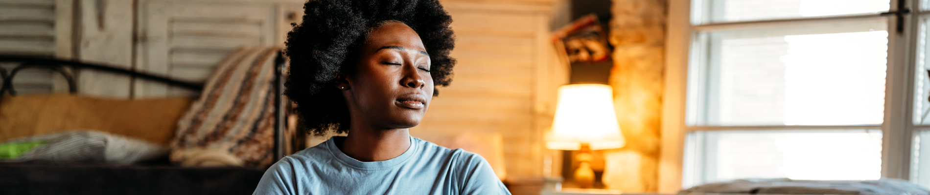 woman with eyes closed in the middle of living room in thought