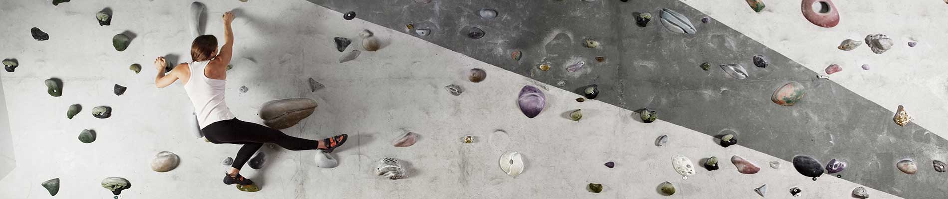 Woman climbing a rock wall without safety rope