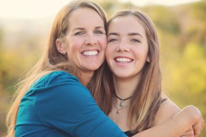 Mother and daughter smiling and embracing