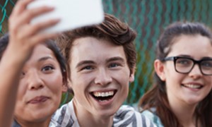 Three teens smiling and taking a selfie